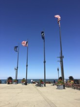 Flags waving on a sunny day along a pier with clear blue sky and plants, chicago, illinois, usa