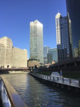 Body of water with urban skyline in the background, lined with skyscrapers and a path, chicago,