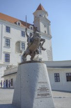 Majestic equestrian statue in front of a historic castle building under a clear sky, bratislava,