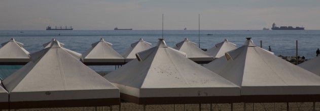 Italy Venice Lido -10 beach tents at the back of the Adriatic Sea with cargo ships in the roadstead