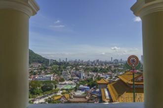 View of a city with temple buildings and modern structures under a clear sky, penang, malaysia