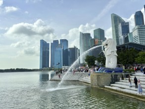 Merlion fountain spouts water in front of the impressive skyline and clouds, singapore