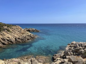 Rocky cliffs tower over the turquoise sea under a clear sky, cagliari, sardinia, italy