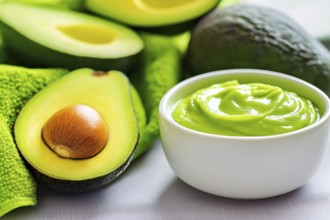 Fresh avocados and a bowl of creamy avocado face mask on a light-coloured background, generated