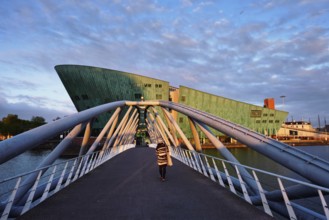 AMSTERDAM, NETHERLANDS, MAY 9, 2017: NEMO Science museum and Mr. J. van der Veldebrug bridge. It is