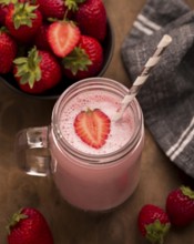 High angle strawberry milkshake with straw