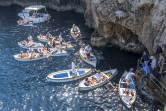 Italy, Gulf of Naples. Island of Capri, Blue Grotto. Boats with tourists in front of the entrance