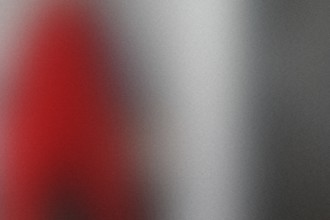 Red object is in the background of a gray photo