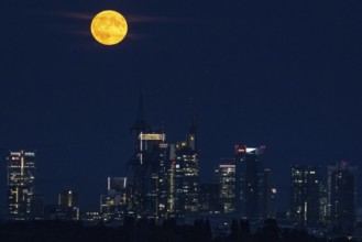 The full moon passes over the Frankfurt banking skyline, Frankfurt, Hesse, Germany, Europe