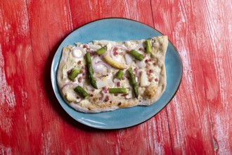 French tarte flambee on red wood