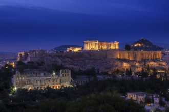 Iconic view of Acropolis hill in Athens, Greece at night. Delicate lights of Parthenon and Odeon