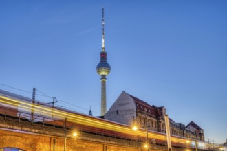 The famous TV tower in Berlin at dusk with a motionless S-Bahn train