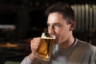 Close up man drinking beer from mug