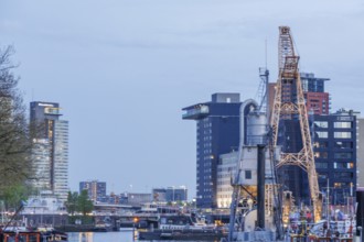 Modern and traditional structures stretch along the harbour at dusk, Rotterdam, Netherlands