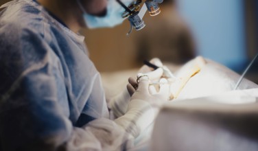 Work of a surgeon in the operating room, a surgical instrument in hand