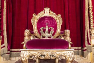 Genoa, Italy, 06 August 2023: Royal Palace, throne room interior, gold and red velvet, Europe