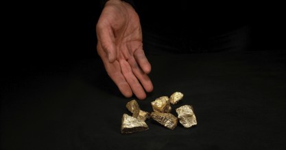 Hand and Gold Nuggets, Nugget, Falling on Black Background