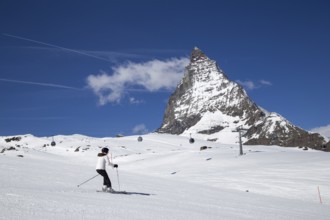 Zermatt, Switzerland, April 12, 2017: A woman skiing in front of the famous Matterhorn, Europe