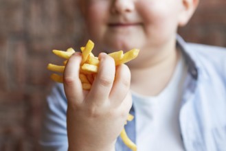 Close up boy holding french fries