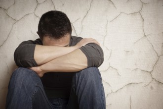 depression devastated young man hiding his face
