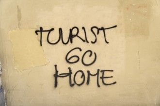 Tourist go home lettering on a wall in Barcelona, Spain, Europe