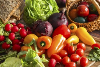 Colourful fresh vegetables, including peppers, tomatoes and radishes, surrounded by bread and
