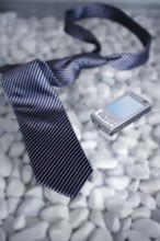 Businessman on a break, left his tie and phone on a modern white stones table