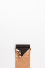 Dark chocolate bar golden wrapper white background