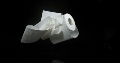 Roll of Toilet Paper Falling on Black Background