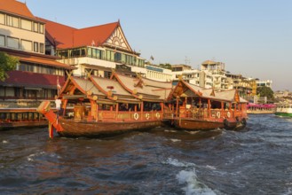 Ships at the pier for river cruise on a rice barge on the Chao Phraya river in Bangkok. Traditional