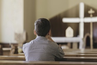Back view young boy praying church. High resolution photo