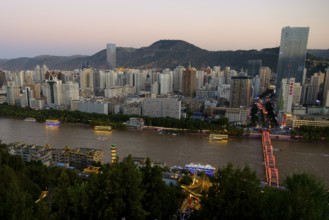 The Yellow River or Huang He in Lanzhou with the city skyline at sunset