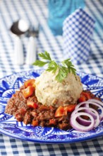 Goulash with dumplings on a blue plate