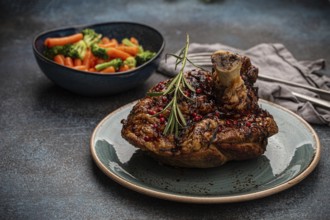 Delicious roasted ham or pork knuckle with glazed brown crispy skin, red pepper berries and