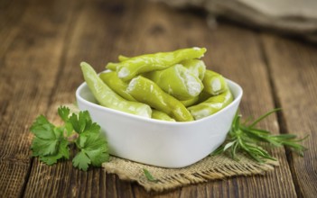 Fresh made Green Chilis (filled with cheese) on an old and rustic wooden table (selective focus,