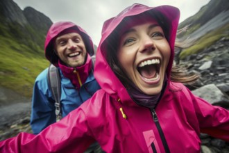 Young couple in mackintosh stands beaming with joy in free nature. behind Nordic landscape and