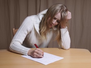 lovesick young woman writing letter with broken heart