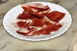At Arcos, slices of pink ham served on a white plate, Andalusia, Spain, Europe