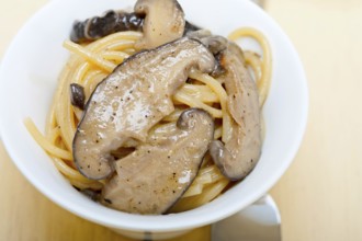 Italian spaghetti pasta and fresh wild mushrooms on rustic wood table