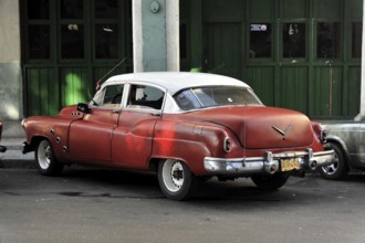 A red vintage car parked on a street corner in Cuba, Havana, Cuba, Central America