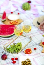 Picnic background with white wine on green grass close-up
