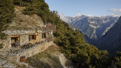 Entrance to the gorge, entrance, ticket office in the rock, terrace, snow-capped mountains,