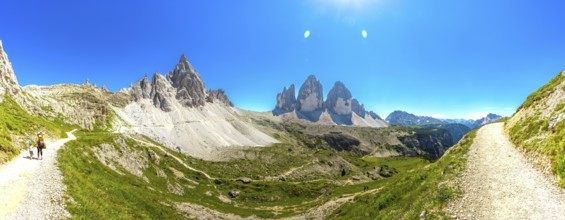 Panoramic. Hikers enjoying a sunny summer day on a scenic mountain trail near the iconic tre cime
