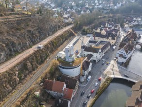 Panorama of a town with river and streets, in the foreground a building site with crane, stairway