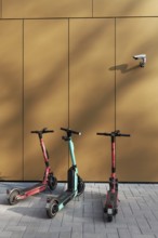 Three e-scooters correctly parked on the pavement, under a surveillance camera, Düsseldorf, North