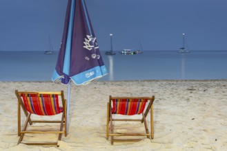 Abandoned deckchairs and parasol after sunset at Charlie Beach, Koh Mook Island, Andaman Sea,