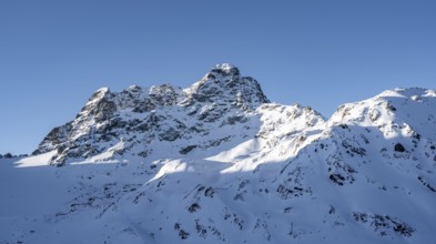 Mountain peak Piz Kesch with snow, view at the Kesch hut in winter, Grisons Haute Route, Albula