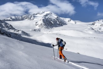Ski tourers, behind the summit of Monte Cevedale, snow-covered mountain landscape, Ortler Alps,