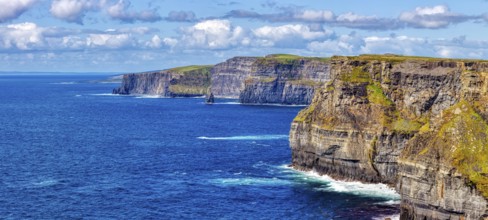 Sweeping views of steep cliffs and azure sea under a cloudy sky, Cliffs of Moher