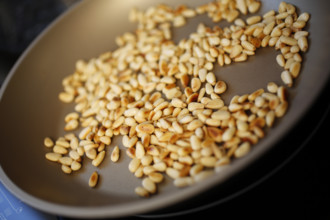 Swabian cuisine, preparation of beef roulade with pine nuts, roasting pine nuts in a pan,